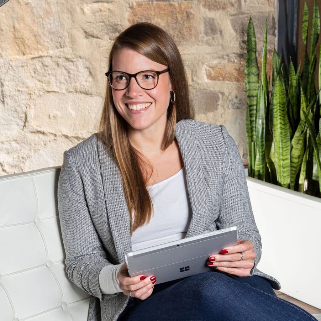 Mitarbeiterin mit ipad oder Surface auf Sessel